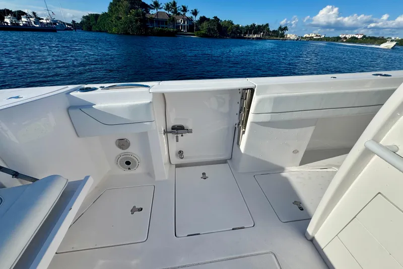 Slide: The Image of 2020 Intrepid 375 Nomad SE boat deck with open hatch, near scenic waterfront. - 15
