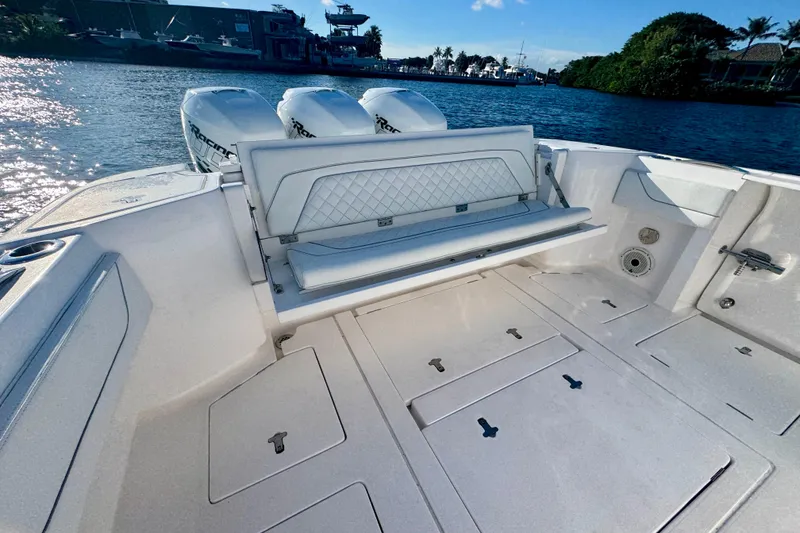 Slide: The Image of 2020 Intrepid 375 Nomad SE boat with spacious deck and seating, docked by the water. - 17