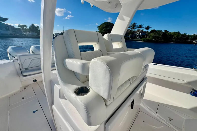 Slide: The Image of 2020 Intrepid 375 Nomad SE boat with luxurious white seating and scenic waterfront view. - 22