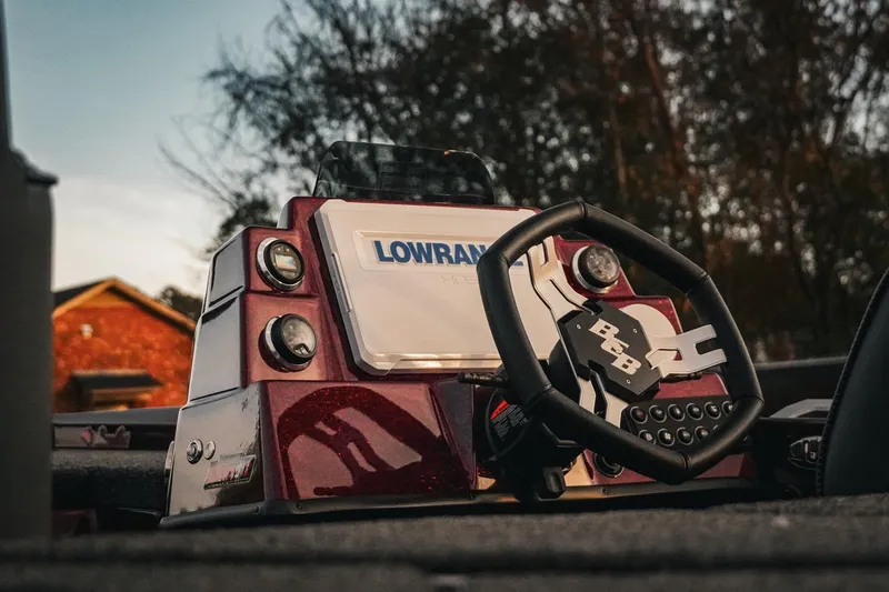 Slide: The Image of 2026 Bass Cat Lynx STS boat dashboard with Lowrance electronics and steering wheel. - 11