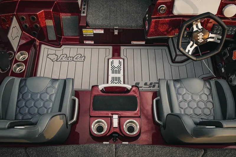 Slide: The Image of 2026 Bass Cat Lynx STS boat interior with dual seats, steering wheel, and branded floor mats. - 21