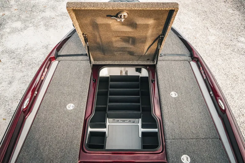 Slide: The Image of 2026 Bass Cat Lynx STS boat storage compartment with open lid, showcasing organized interior. - 22