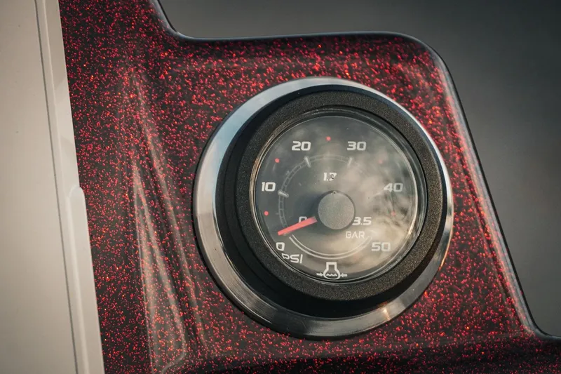 Slide: The Image of Close-up of 2026 Bass Cat Lynx STS gauge on a red-speckled dashboard. - 26