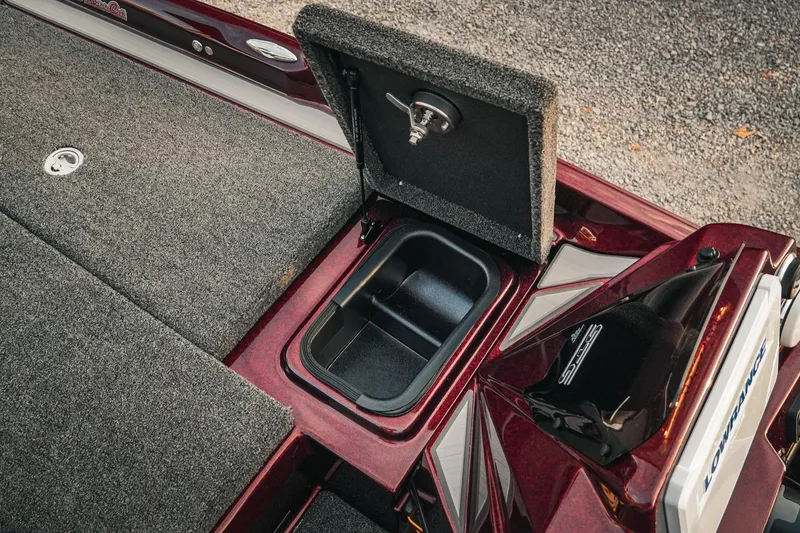Slide: The Image of 2026 Bass Cat Lynx STS boat storage compartment with open lid, showcasing interior details. - 27