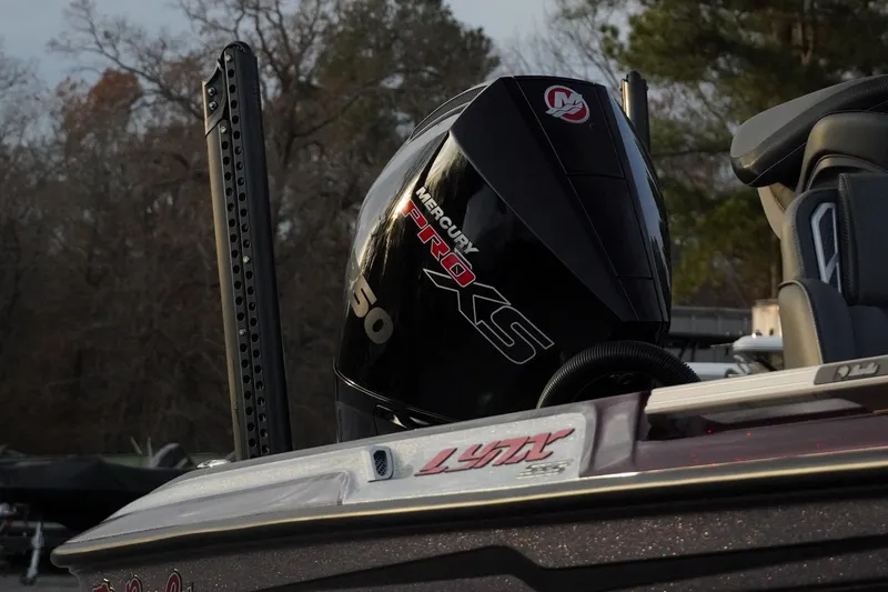 Slide: The Image of 2026 Bass Cat Lynx STS boat with Mercury Pro XS engine in wooded setting. - 6