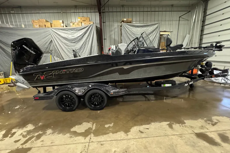 Slide: The Image of 2026 Nitro ZV21 Pro boat in a garage, featuring sleek black design and Mercury engine. - 0