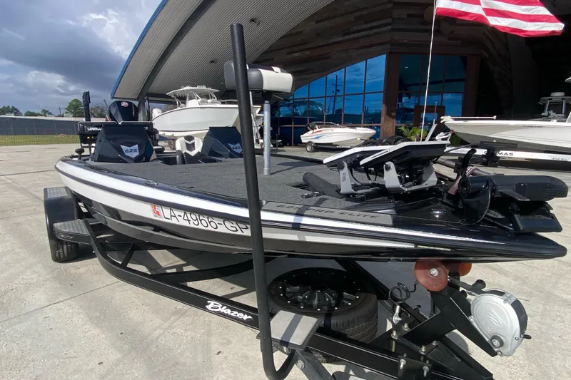 Slide: The Image of 2023 Blazer 625 Pro Elite boat on trailer, displayed outdoors with American flag. - 10