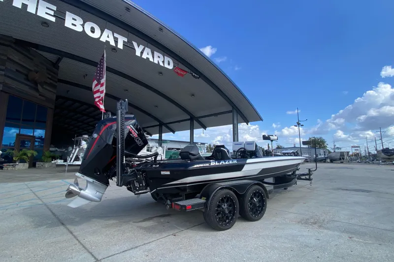 Slide: The Image of 2023 Blazer 625 Pro Elite boat at dealership, under clear blue sky. - 3