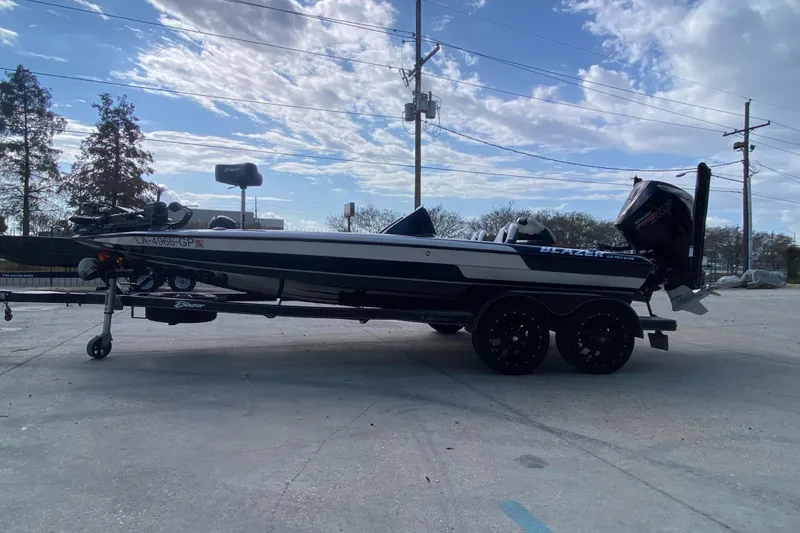 Slide: The Image of 2023 Blazer 625 Pro Elite boat on trailer under a partly cloudy sky. - 6