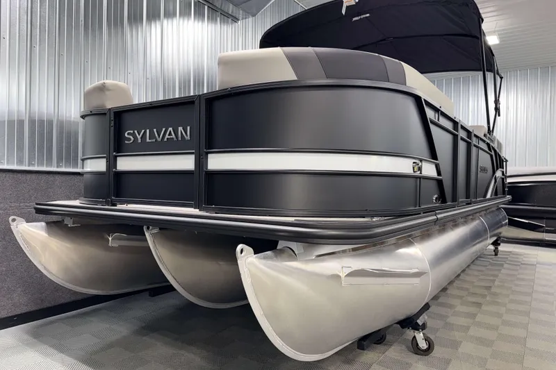 Slide: The Image of 2026 Sylvan L3 SLZ pontoon boat in showroom, featuring sleek black design and modern amenities. - 26