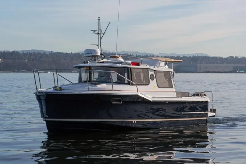 Slide: The Image of Manufacturer Provided Image: 2025 Ranger Tugs R-23 boat on calm water, showcasing sleek design and modern features. - 4