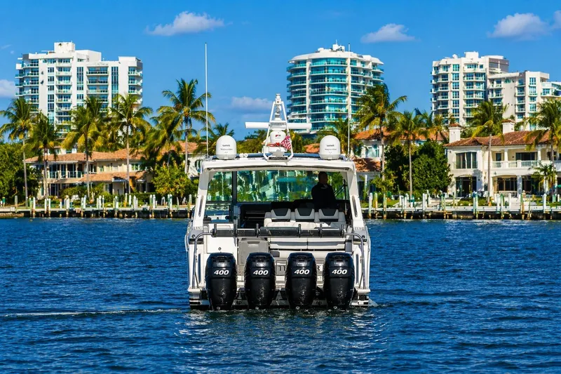 Slide: The Image of 2020 Formula 400 Super Sport Crossover boat cruising near luxury waterfront homes. - 2