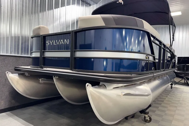 Slide: The Image of 2026 Sylvan L3 SLZ pontoon boat in a showroom, featuring sleek blue and silver design. - 28