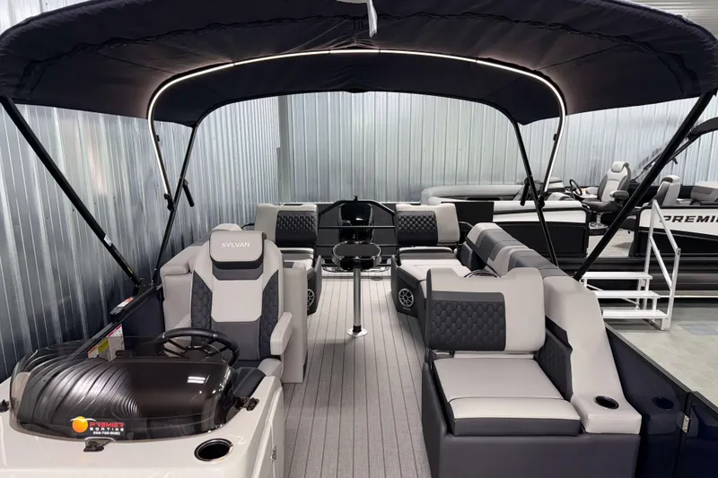 Slide: The Image of 2026 Sylvan L3 SLZ pontoon boat with modern seating and canopy in showroom. - 6