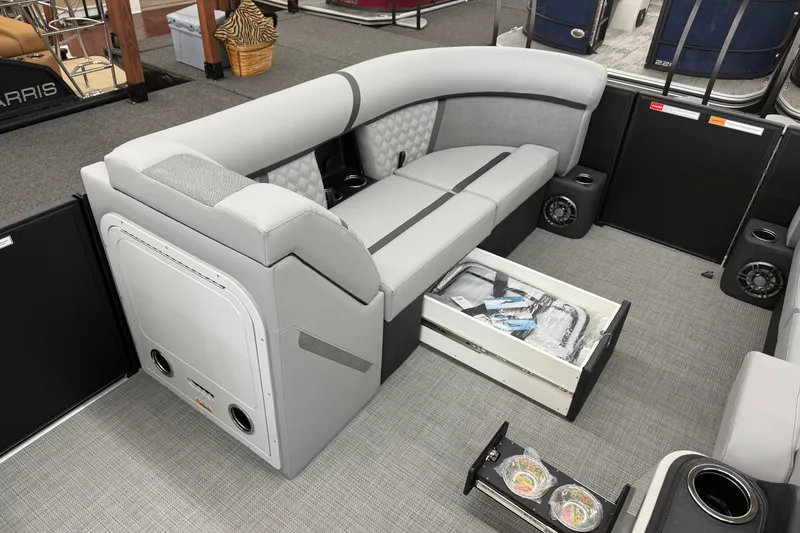 Slide: The Image of 2026 Crest Conquest 215 SLC interior with gray seating, storage drawer, and cup holders. - 8