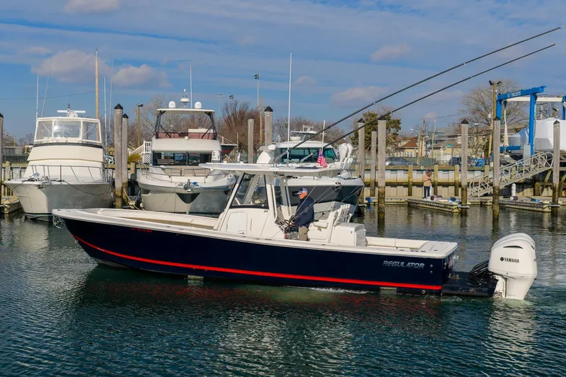 The Image of 2020 Regulator 34 Center Console boat docked in a marina with other vessels. - 0