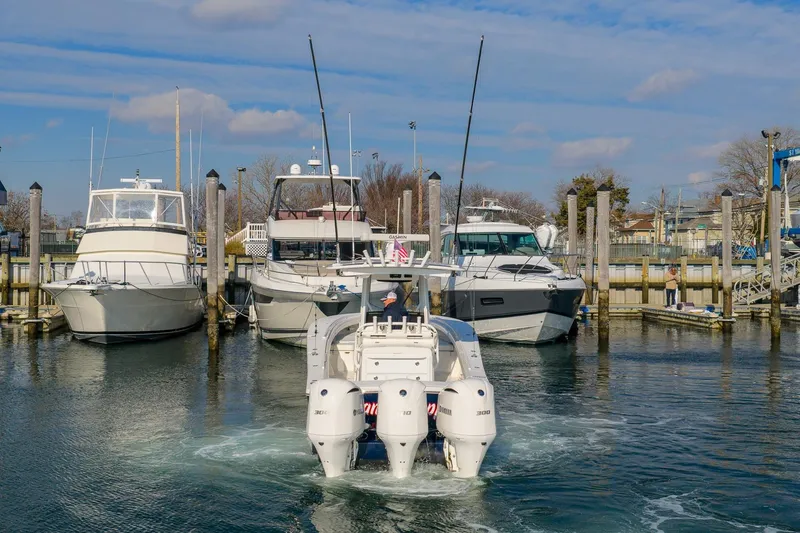 Slide: The Image of 2020 Regulator 34 Center Console boat docked at marina with other vessels. - 3