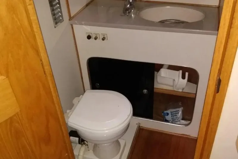 Slide: The Image of 1989 Chris-Craft 381 Catalina bathroom with toilet, sink, and storage cabinet. - 15