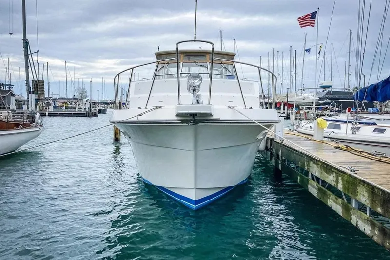 Slide: The Image of 1989 Chris-Craft 381 Catalina yacht docked at marina, American flag in background. - 5