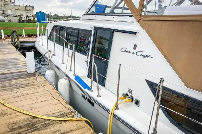 Slide: The Image of 1989 Chris-Craft 381 Catalina yacht docked, featuring sleek design and tan canopy. - 7