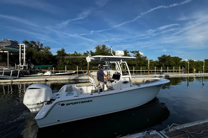 Slide: The Image of 2021 Sportsman Open 242 Center Console boat docked, featuring Yamaha engine, under clear blue sky. - 0