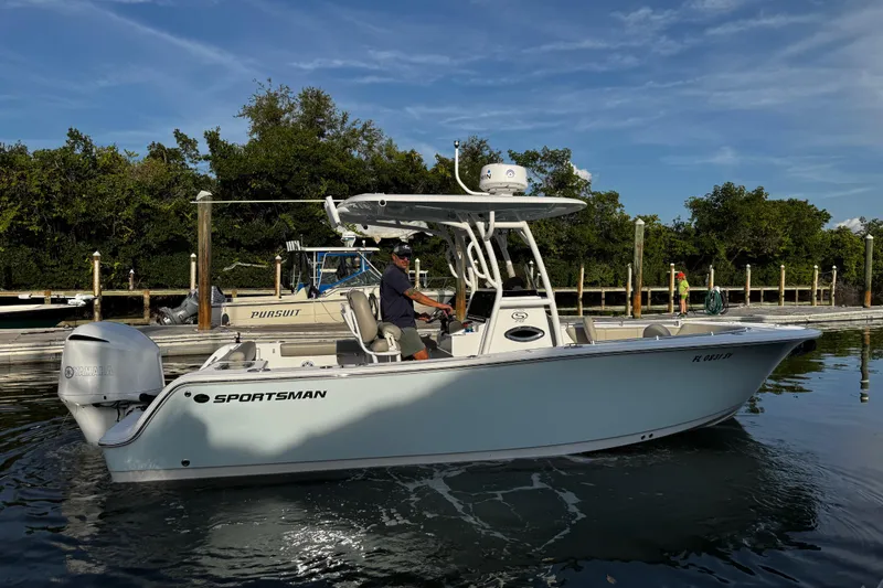 Slide: The Image of 2021 Sportsman Open 242 Center Console boat on calm water near a dock. - 15