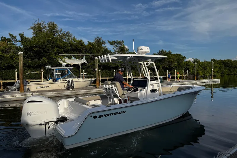 Slide: The Image of 2021 Sportsman Open 242 Center Console boat on calm water near a dock. - 16
