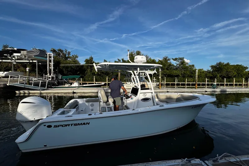 Slide: The Image of 2021 Sportsman Open 242 Center Console boat docked on calm water. - 18
