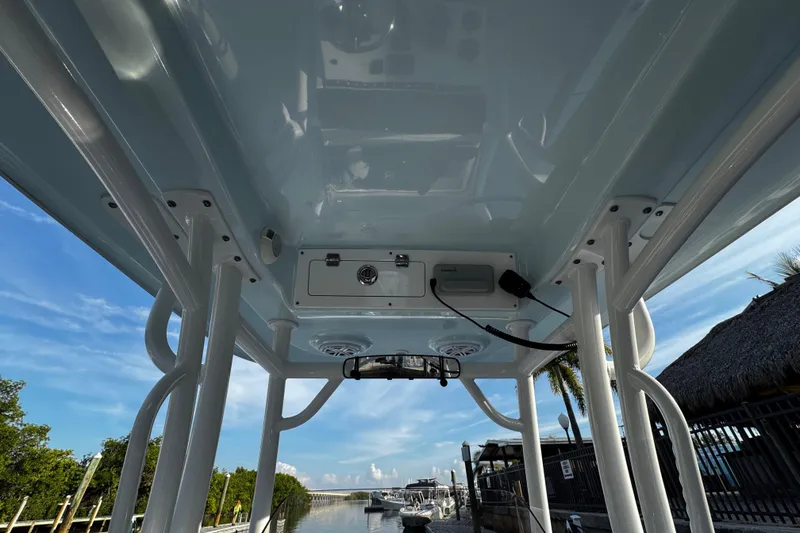 Slide: The Image of 2021 Sportsman Open 242 Center Console boat interior with electronics, docked by a scenic waterway. - 21