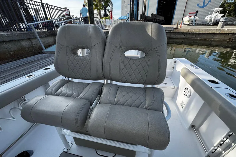 Slide: The Image of 2021 Sportsman Open 242 Center Console boat seats with diamond stitching, dockside view. - 22
