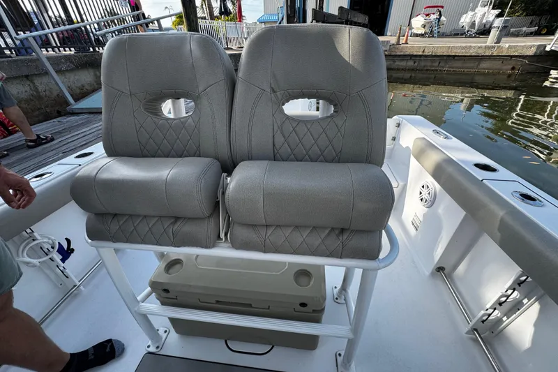Slide: The Image of 2021 Sportsman Open 242 Center Console boat with dual cushioned seats and storage compartment. - 23