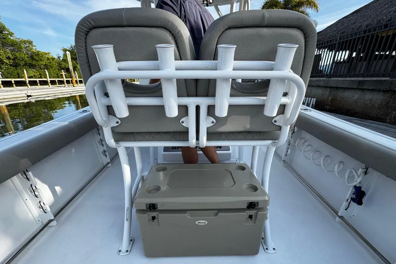 Slide: The Image of 2021 Sportsman Open 242 Center Console boat interior with rod holders and cooler. - 28