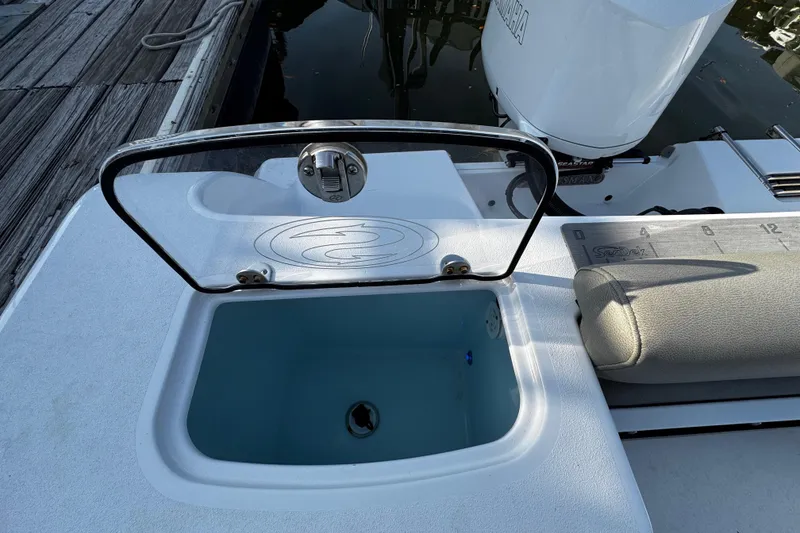 Slide: The Image of 2021 Sportsman Open 242 Center Console boat with open storage compartment near dock. - 29
