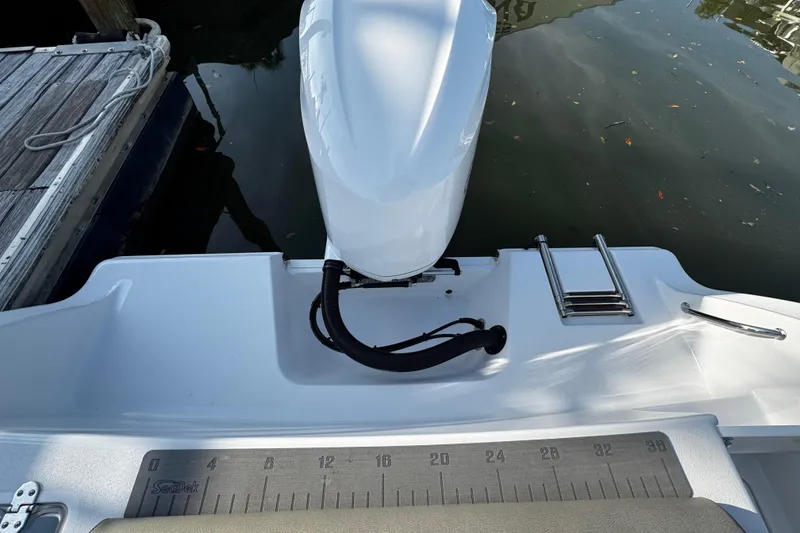 Slide: The Image of 2021 Sportsman Open 242 Center Console boat stern with motor and swim ladder. - 30