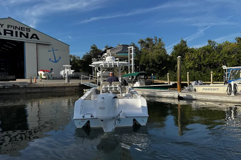 Slide: The Image of 2021 Sportsman Open 242 Center Console boat at marina dock under clear blue sky. - 5