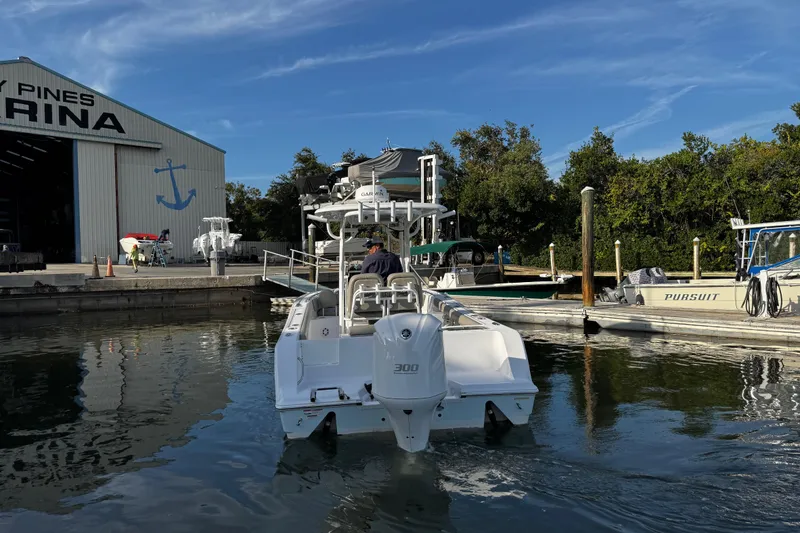 Slide: The Image of 2021 Sportsman Open 242 Center Console boat at marina dock under clear blue sky. - 7