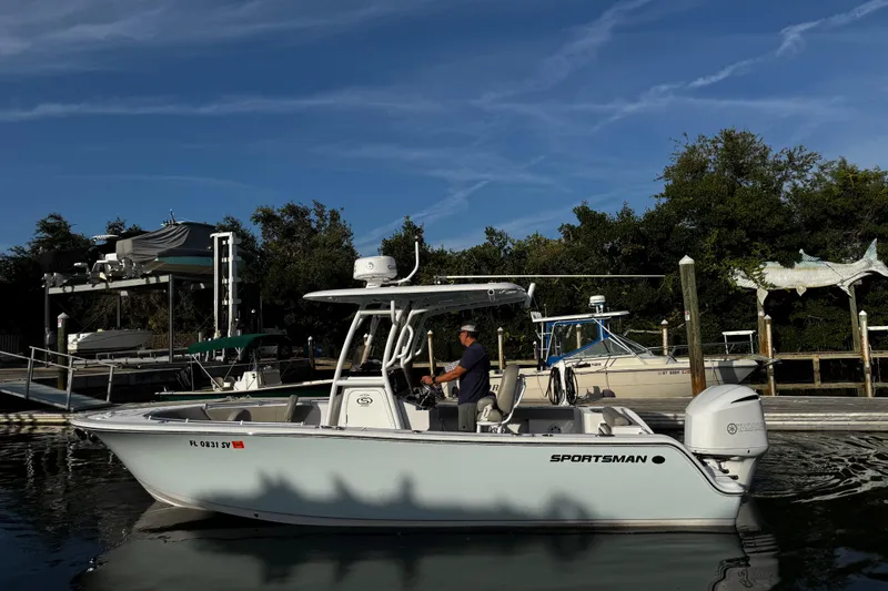 Slide: The Image of 2021 Sportsman Open 242 Center Console boat docked at marina under clear blue sky. - 8