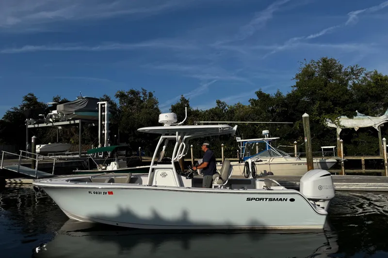Slide: The Image of 2021 Sportsman Open 242 Center Console boat docked at marina under clear blue sky. - 9