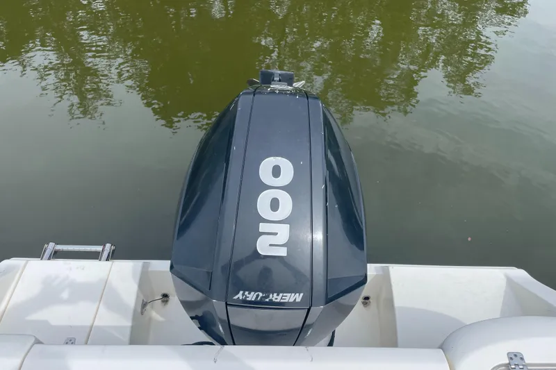 Slide: The Image of Outboard motor on 2021 Cobia 220 Dual Console boat, docked on calm water. - 5