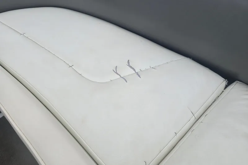 Slide: The Image of Torn white upholstery on 2001 Cobalt 232 boat seat, showing wear and damage. - 18
