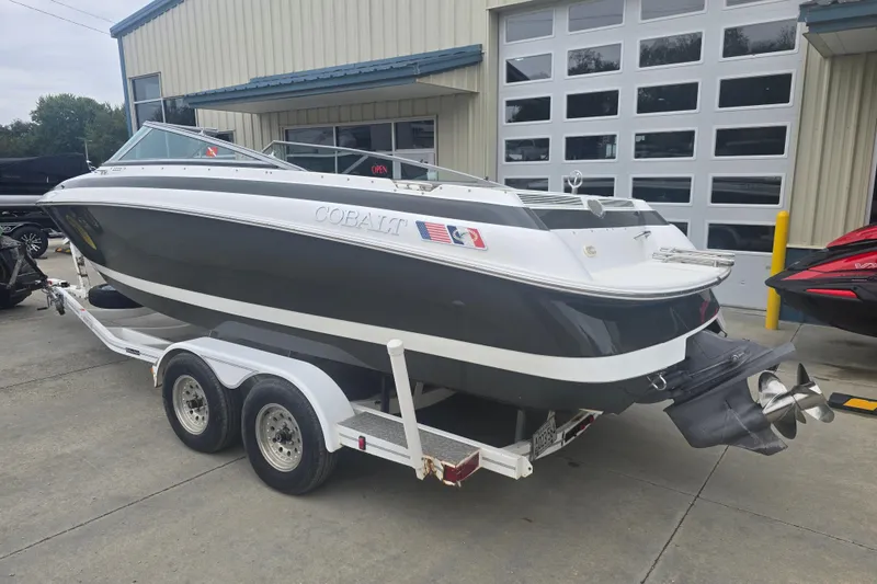 Slide: The Image of 2001 Cobalt 232 boat on trailer outside a garage. - 2