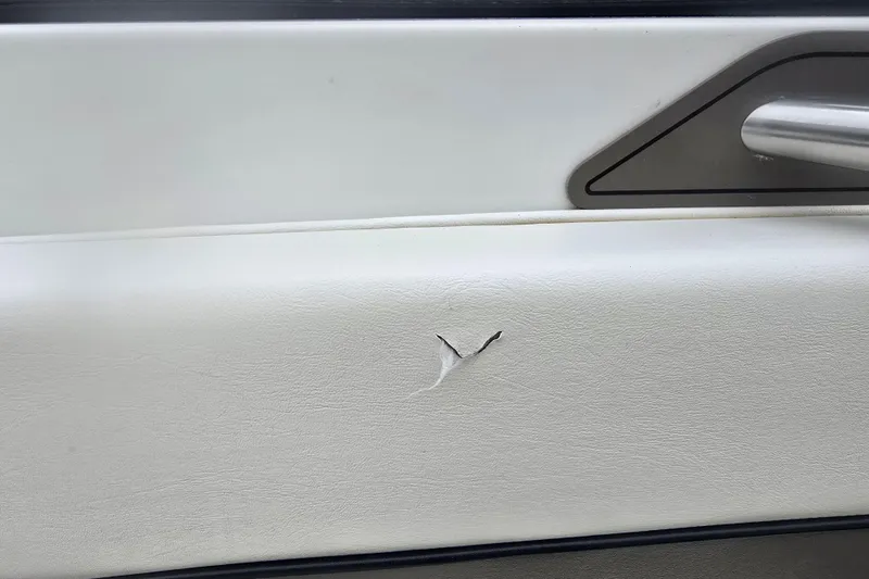 Slide: The Image of Torn white interior panel of 2001 Cobalt 232 boat with visible handle. - 22