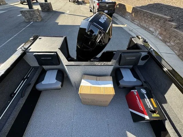 Slide: The Image of 2024 Crestliner 2050 Commander boat interior with seating, outboard motor, and packaging boxes. - 12