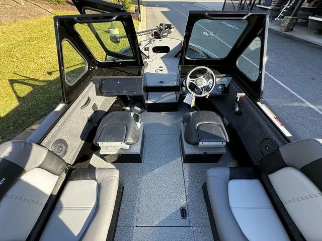 Slide: The Image of 2024 Crestliner 2050 Commander boat interior with seating and steering wheel, showcasing modern design. - 5