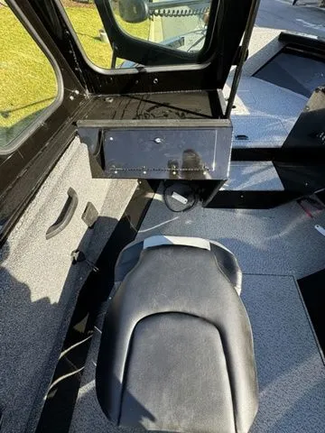 Slide: The Image of 2024 Crestliner 2050 Commander interior with black seat and storage compartment. - 7