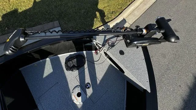 Slide: The Image of 2024 Crestliner 2050 Commander boat with trolling motor on deck, parked on pavement. - 9