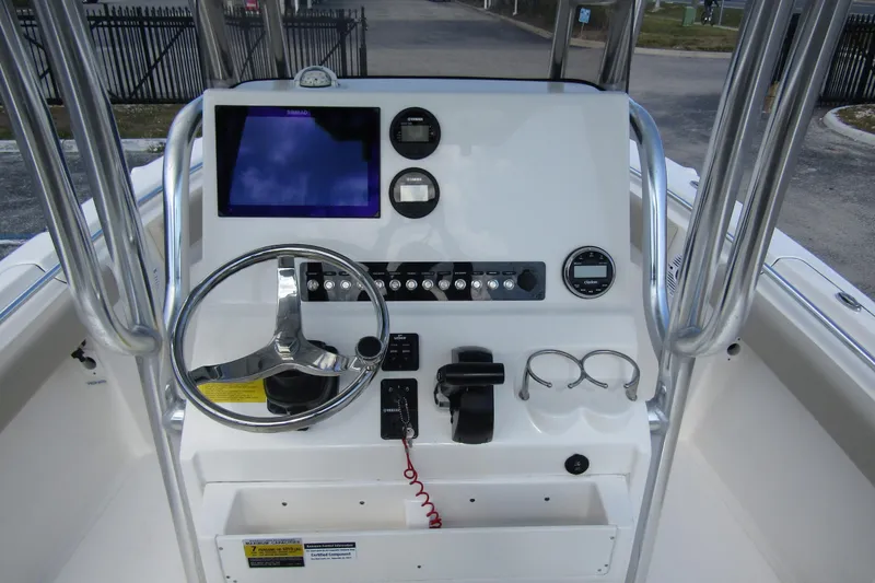 Slide: The Image of 2022 Key West 219 FS boat console with steering wheel and navigation display. - 17