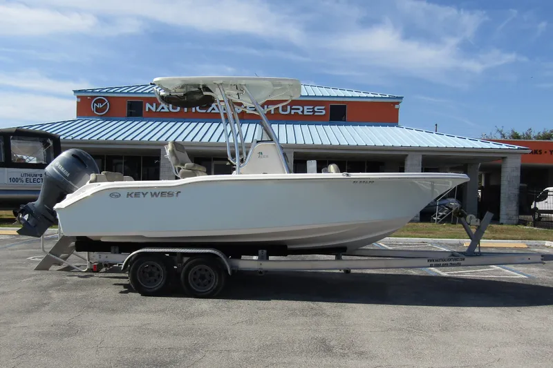 Slide: The Image of 2022 Key West 219 FS boat on trailer outside Nautical Ventures store. - 3