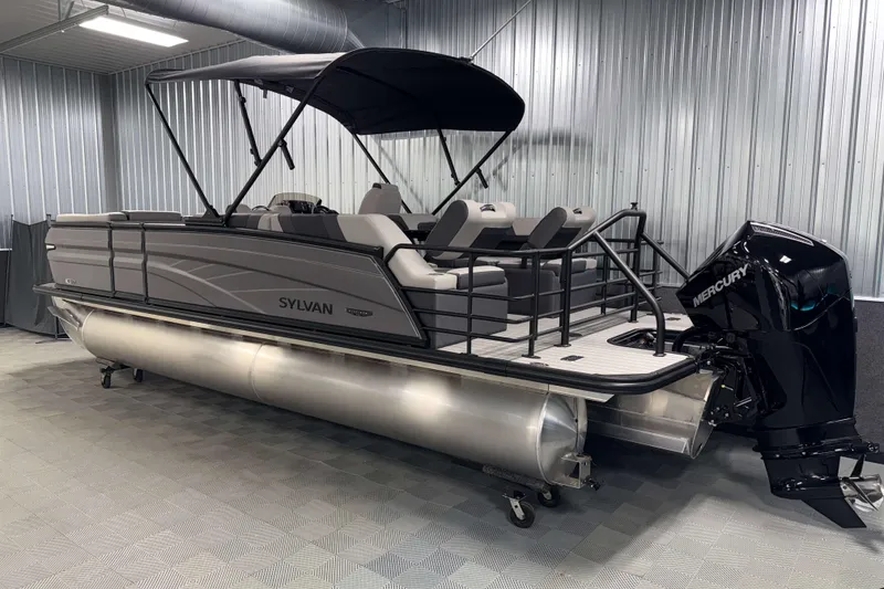 Slide: The Image of 2026 Sylvan L3 SLZ Platinum pontoon boat with Mercury outboard in a metal-walled showroom. - 34