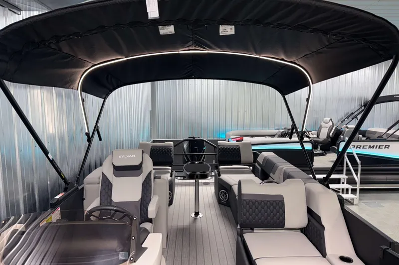 Slide: The Image of 2026 Sylvan L3 SLZ Platinum pontoon boat with luxurious seating and canopy in showroom. - 7